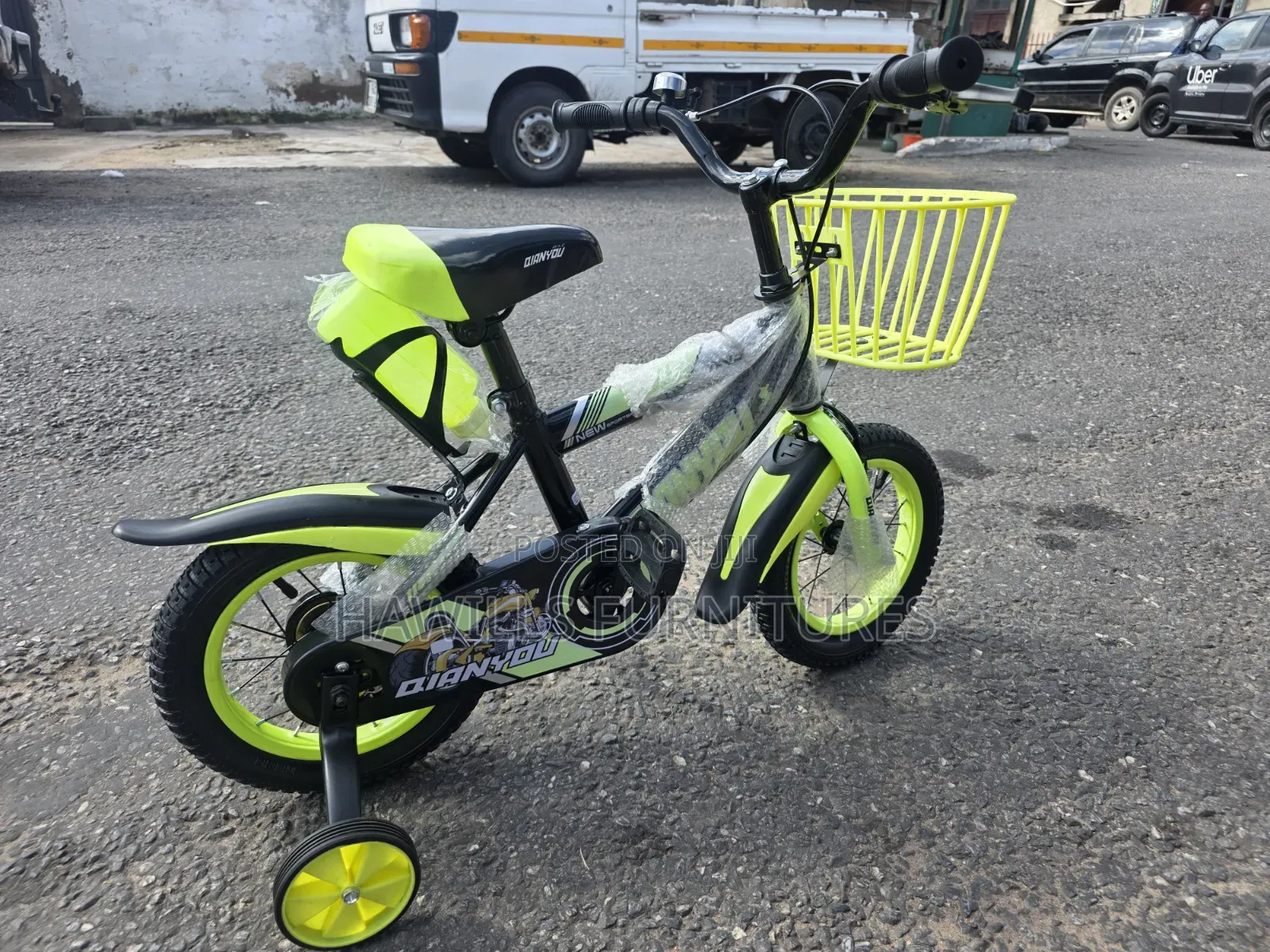Green Bicycle Features Matching Storage Basket and Training Wheels.