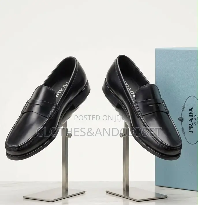 A Pair of Black Leather Penny Loafers Featuring a Keeper Strap