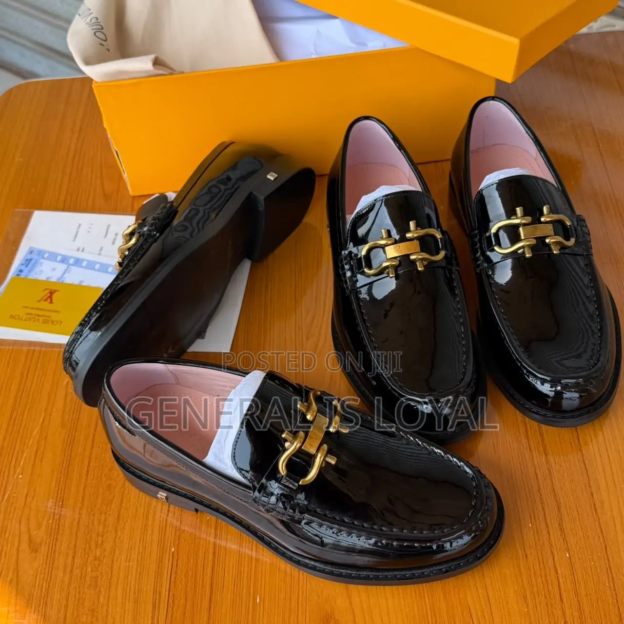 Black Patent Leather Loafers Mirror a Gold-Tone Metallic Buckle